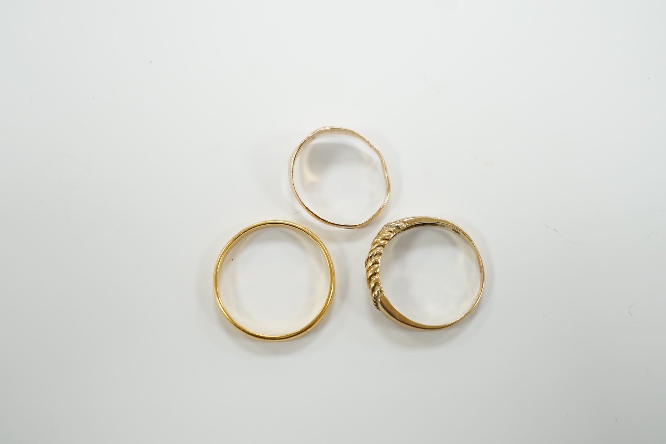 A 22ct gold wedding band, 3.4 grams, a 9ct gold signet ring, 16 grams and a yellow metal ring.